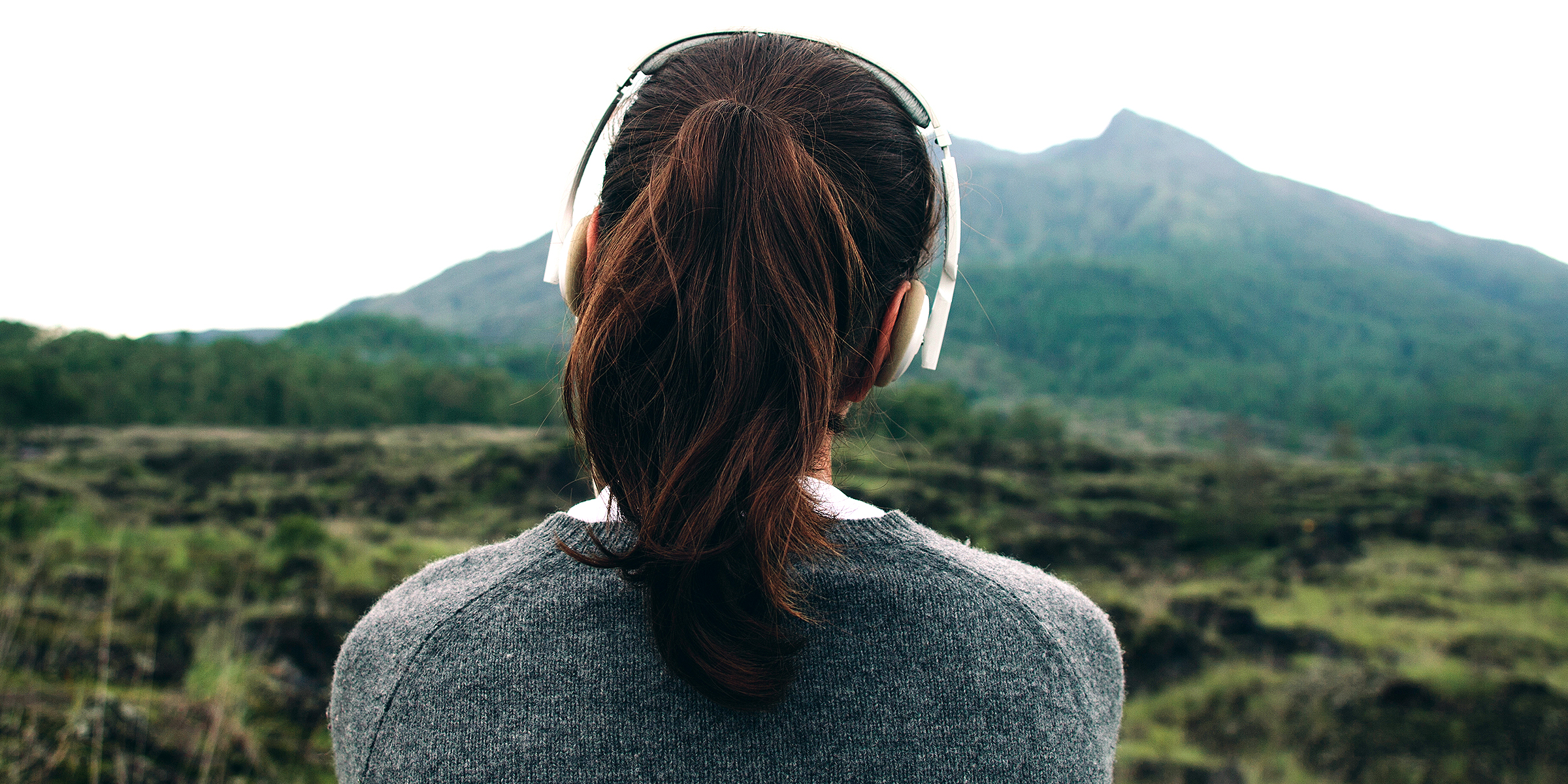 A woman listens to music on top of a mountain | Source: Shutterstock