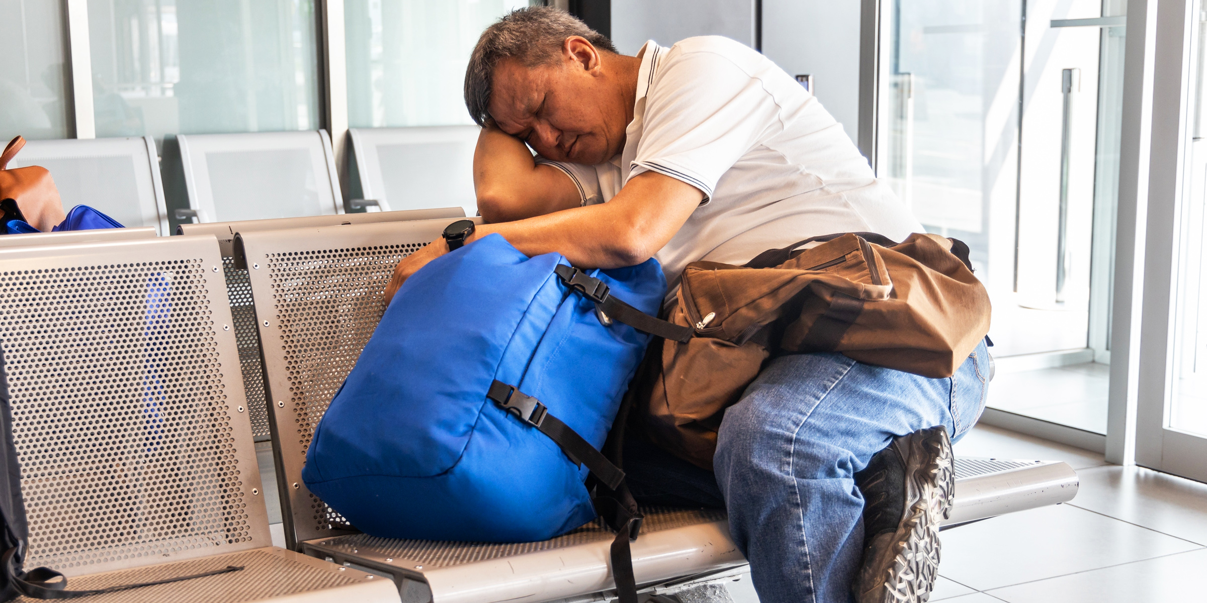 A man sleeping in an airport | Source: Shutterstock